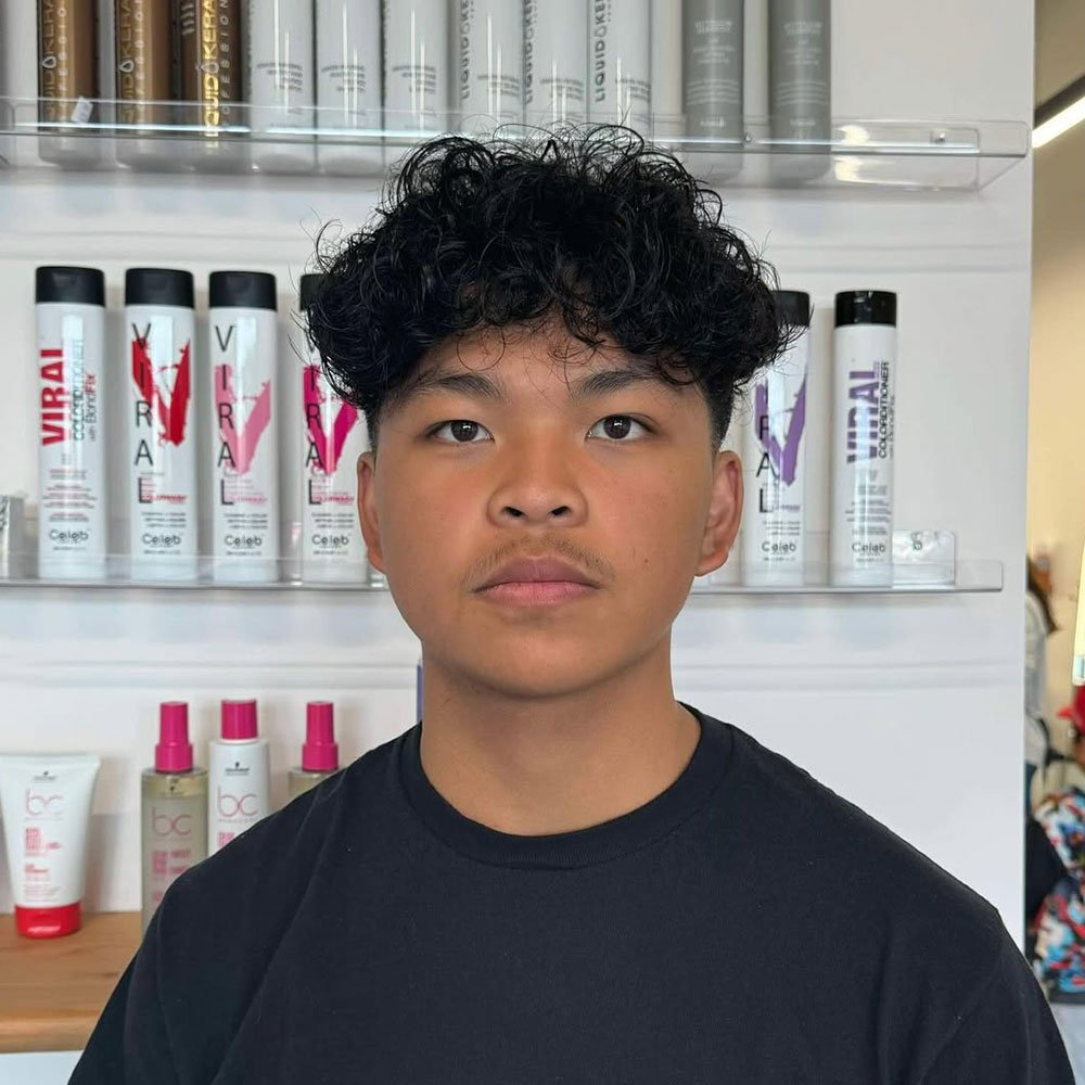 Low taper fade with curly hair on top