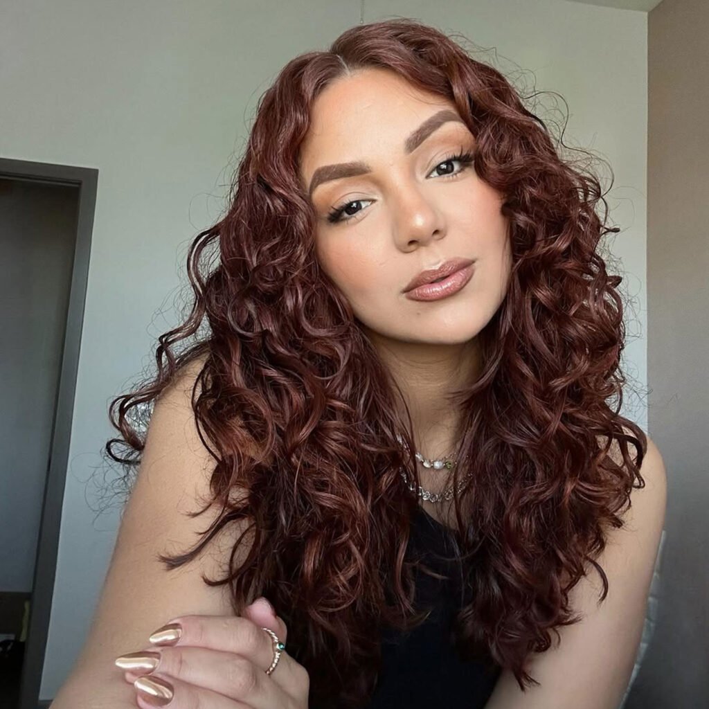 Mid-length defined curls with a clean part.