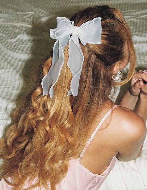 Half-up loose waves with sheer white bow
