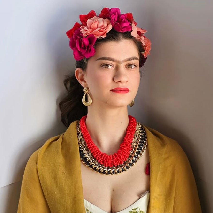 Braided updo wrapped with flowers, inspired by traditional Mexican style.