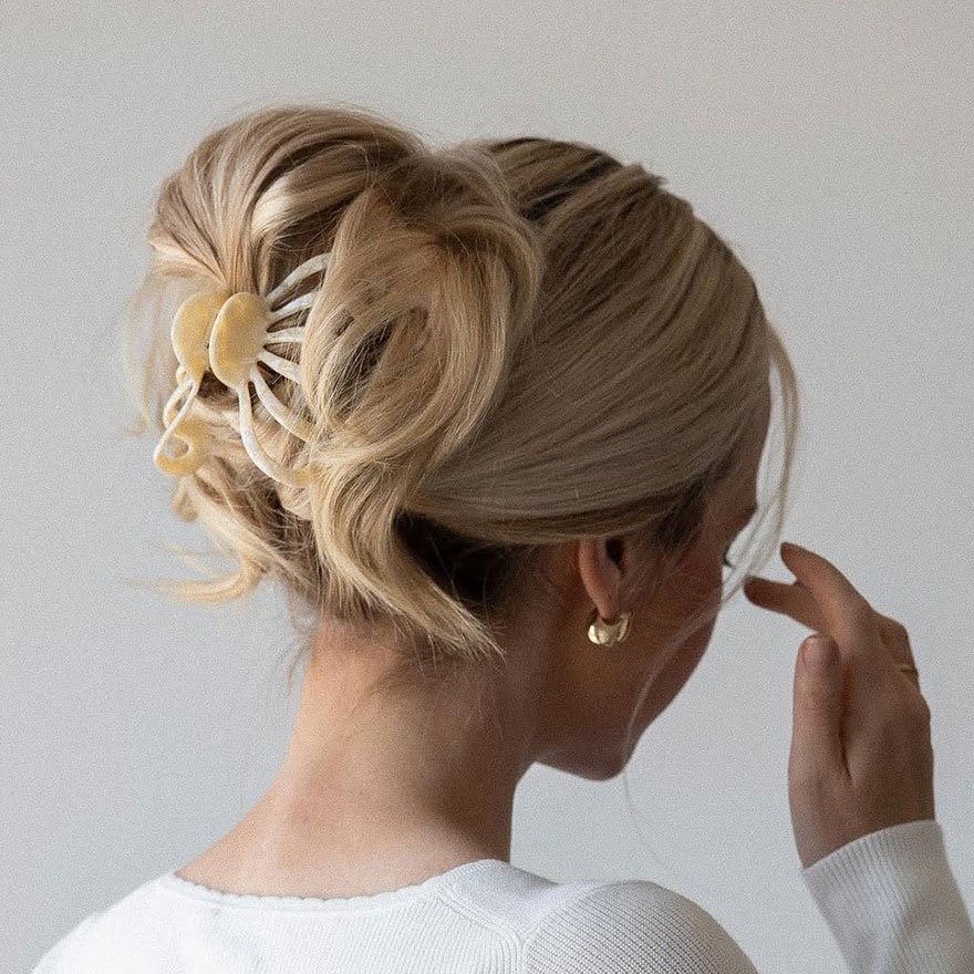 Messy claw clip updo hairstyle with blonde hair