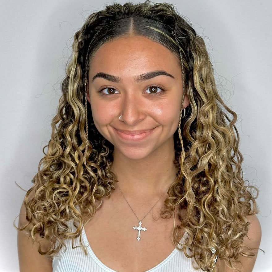 Natural defined curly hair with middle part hairstyle.