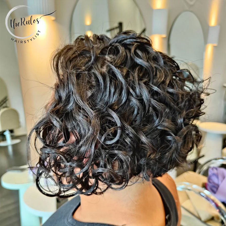 Short curly bob hairstyle with defined ringlets framing the face.