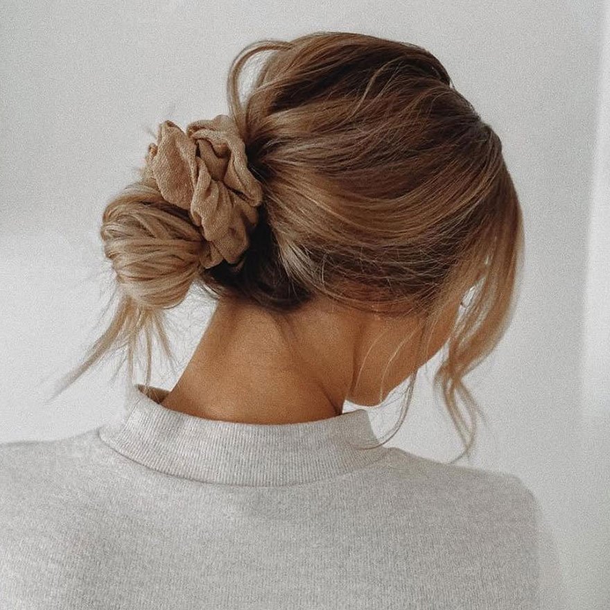 Soft scrunchie bun hairstyle, elegant low updo for women.