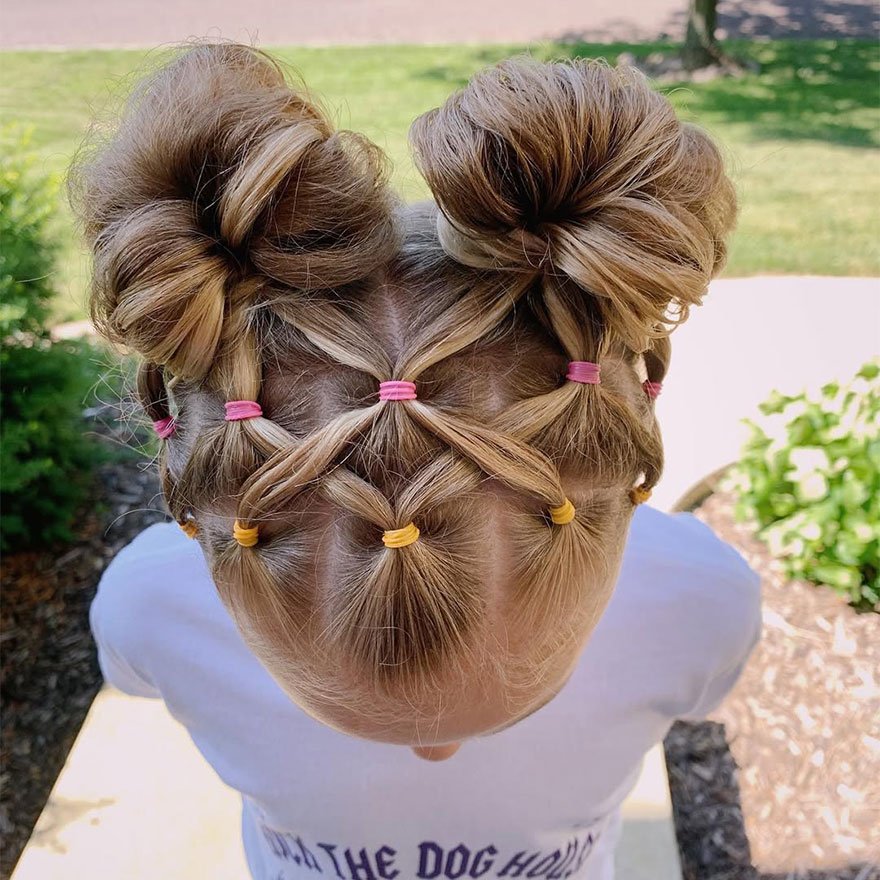 Cute toddler hairstyle with two high braided buns and criss-cross sectioning on the back of the head.