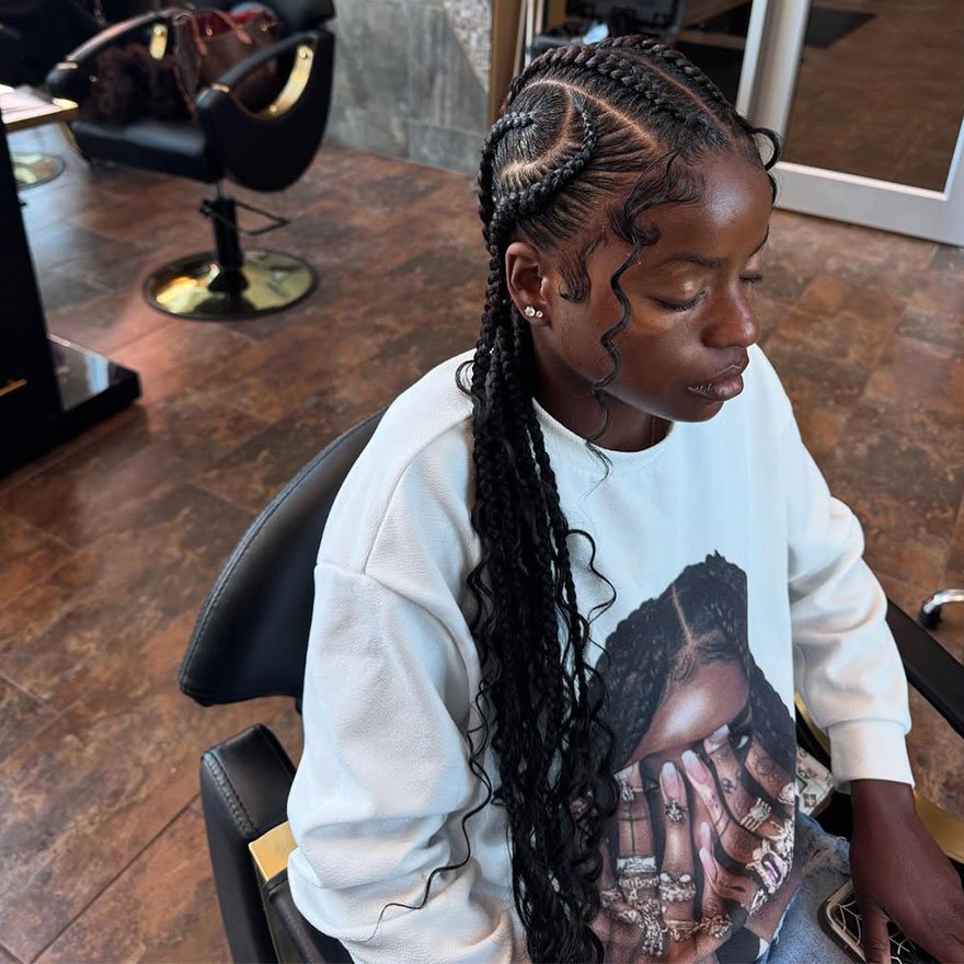 Curved cornrow braids styled with side curls &mdash; protective hairstyle for natural curly hair