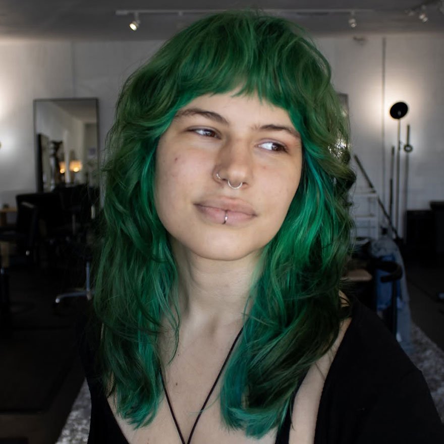 Green shag haircut with blunt bangs and bright green color.