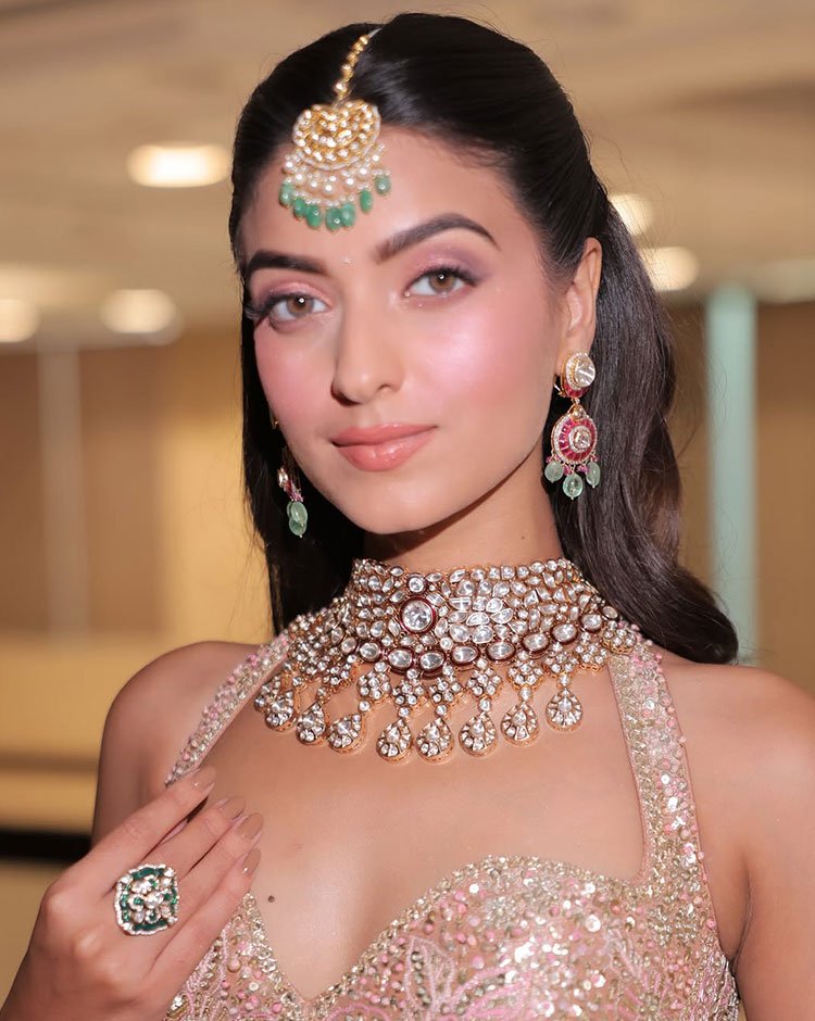 Middle-part low bun bridal hairstyle with maang tikka