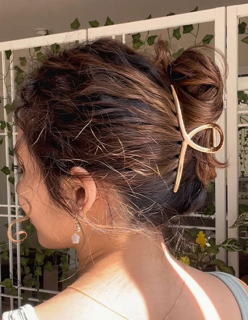 Messy claw-clip updo hairstyle for women, showing loose textured hair secured with a claw clip.