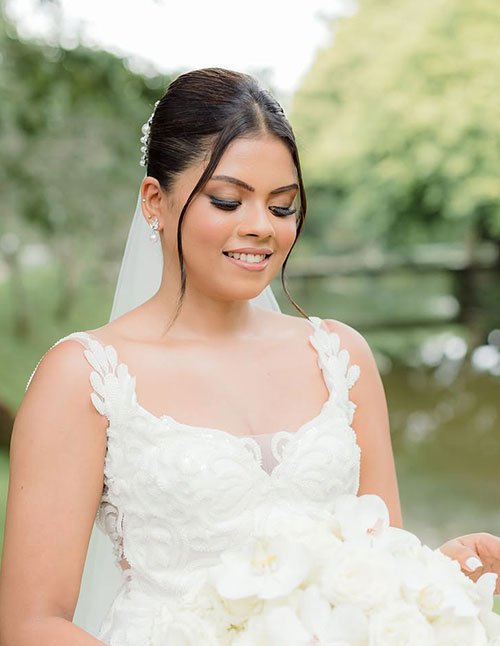 Bride with a sleek low bun and soft face-framing strands.