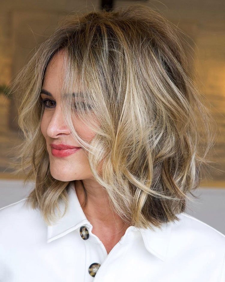 Textured layered lob haircut with soft blonde highlights