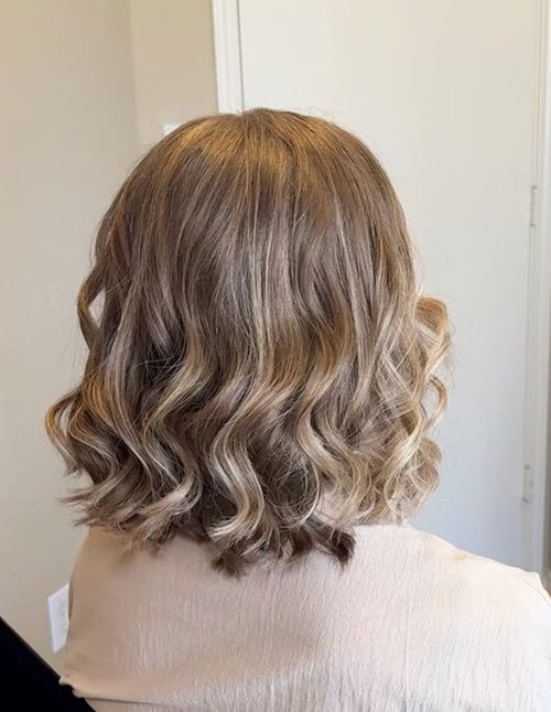 Wavy bob wedding hairstyle with soft curls and blonde highlights