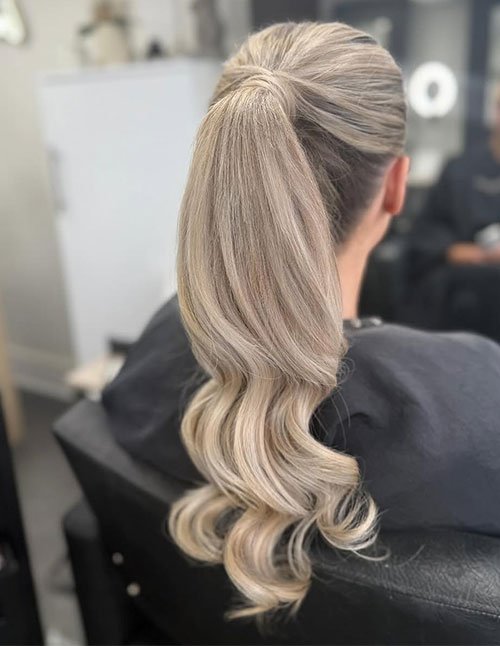 Slick back low ponytail with soft waves hairstyle