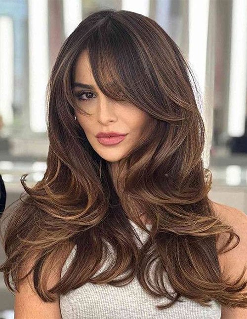 Long layered haircut with swoopy curtain bangs
