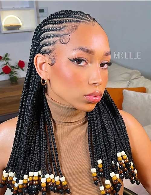 African braids with beads featuring neat cornrow-to-box braids, styled sleek with a side swirl edge detail and bead-decorated ends.
