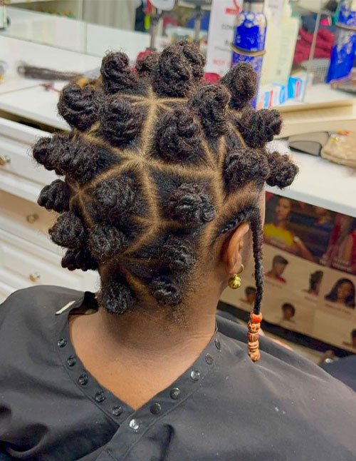 Back view of natural hair styled into neat Bantu knots with precise square parting.
