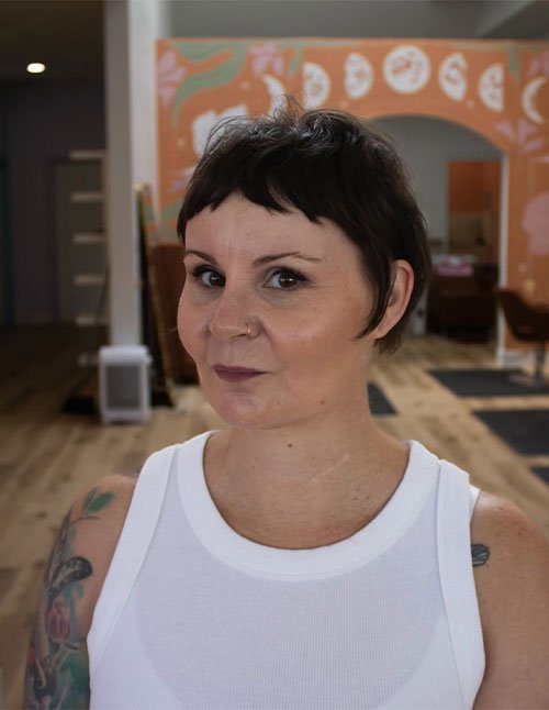 Woman with a bixie haircut featuring short layers and micro bangs.