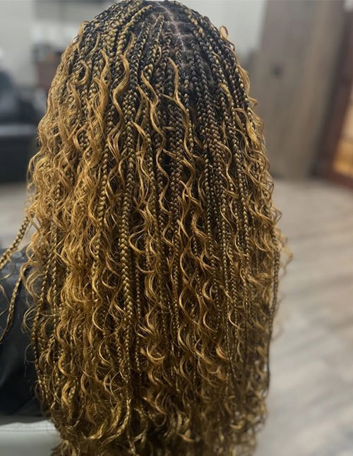 Boho golden knotless braids with curly pieces throughout, showing small braids at the crown blending into loose, defined curls in a honey-blonde mix.