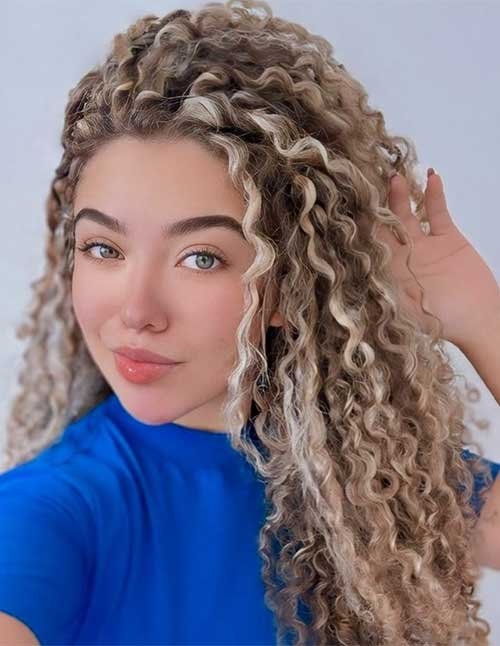 Front view of defined, bouncy curls with light blonde highlights framing the face.