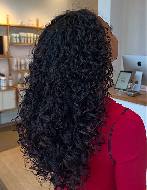 Side/back view of long, bouncy curls with defined ringlets and shine.