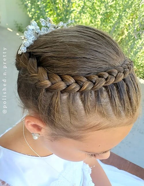 Braided crown updo with a thick side braid wrapped across the head into a smooth bun, finished with a sparkling hair accessory.