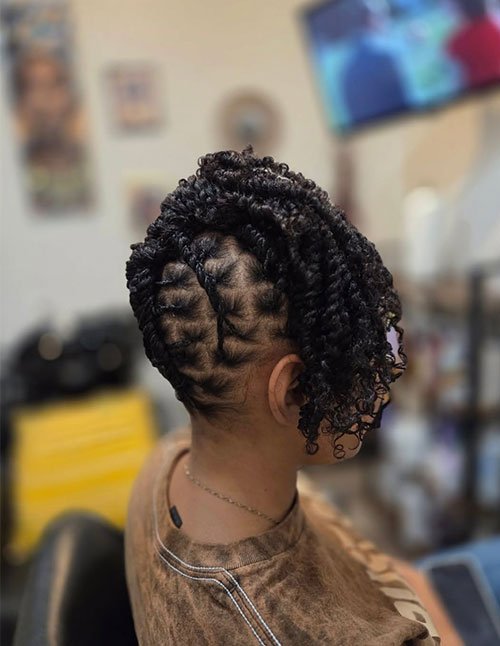 Braided curly faux hawk with neat cornrow sides and defined curls styled upward at the center.