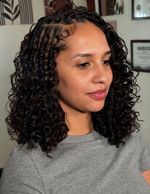 Girl with shoulder-length curly hair styled with small braids along the front and defined curls framing the face.