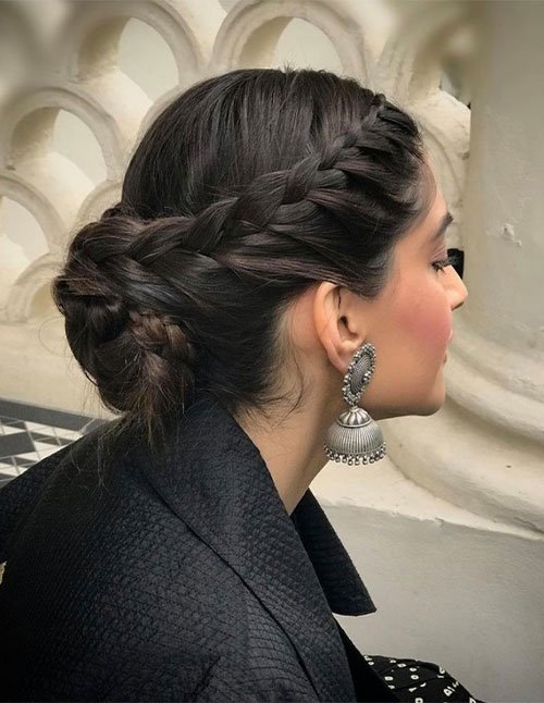 Side view of a woman with a crown braid leading into a low bun.