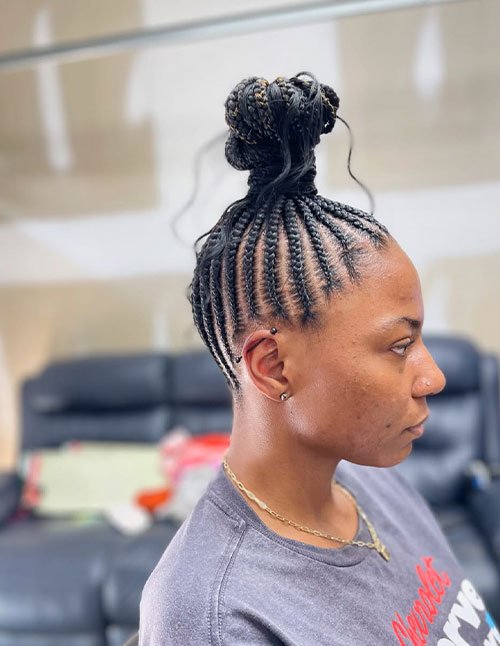Braided top knot hairstyle with tight cornrows gathered into a high bun