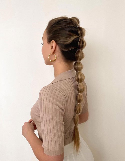 Bubble braid hairstyle with long sleek ponytail and evenly spaced sections
