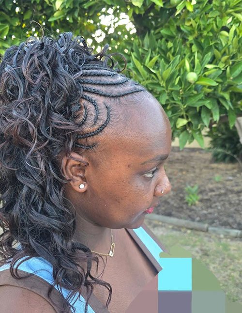 Classic Fulani braids with curved side cornrows and loose curly hair flowing at the back.