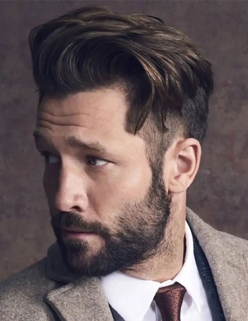 Man with a medium-length swept-back quiff, textured top, and short faded sides, shown in a side-profile portrait.