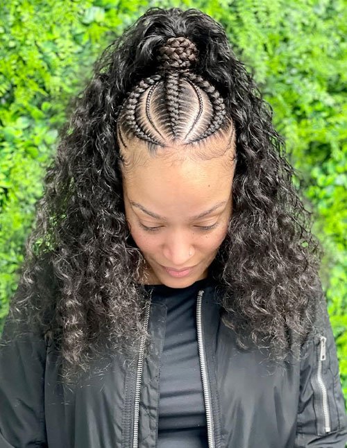 Cornrow ponytail hairstyle with clean center-parted braids gathered into a high ponytail and soft, defined curls flowing down.