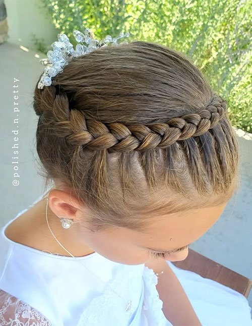 Smooth crown braid wrapped around a low bun with a crystal hairpiece.