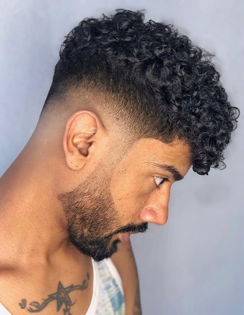 Curly High Top haircut with tight curls on top and a clean fade on the sides and back.