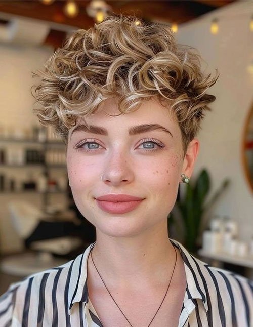 Curly pixie haircut with textured top and short tapered sides