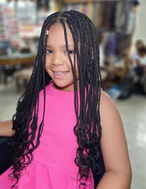 Cute box braids with loose curly ends on a child, featuring small neat braids with face-framing pieces and long wavy tips.