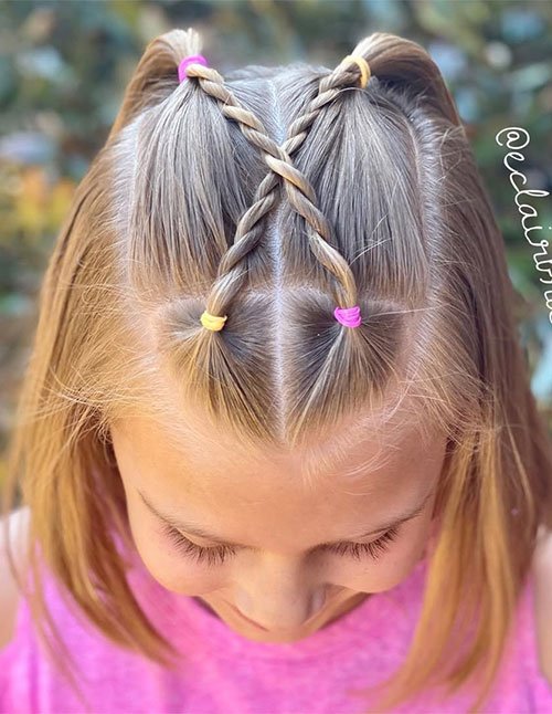 Double rope twist half-up hairstyle on a child, secured with colorful hair ties.
