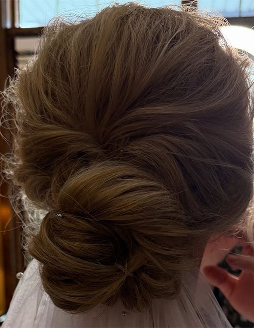 Elegant Winter Updo featuring a smooth low chignon with a soft, polished finish.