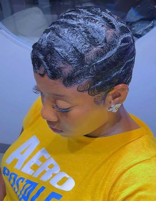 Side view of short hair styled into sleek finger waves with defined S-shaped patterns and laid baby hairs.