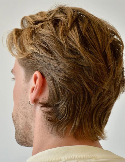 Medium-long layered hair with natural movement, brushed back with a soft, wavy “flow” shape and longer length at the back.