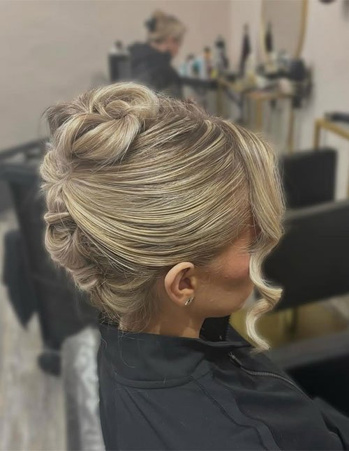 Side view of a classic French twist hairstyle with smooth blonde hair swept back and secured into a sleek rolled updo.