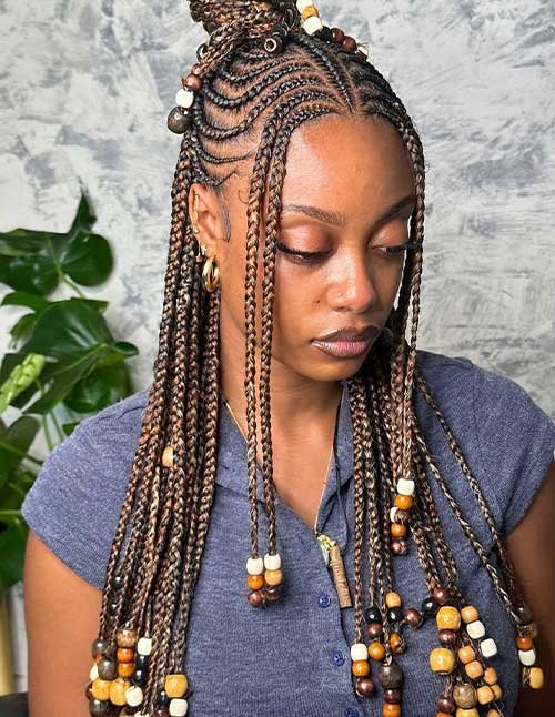 Fulani braids with beads featuring intricate scalp braiding and long braids decorated with wooden beads.