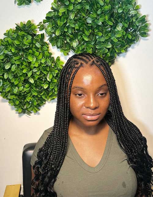 Fulani braids with curly ends featuring neat scalp braiding and long braids finished with loose curls.