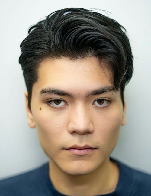 Person wearing a gentleman’s crop haircut with short, neatly styled hair on top and clean, tapered sides for a refined and modern classic look.