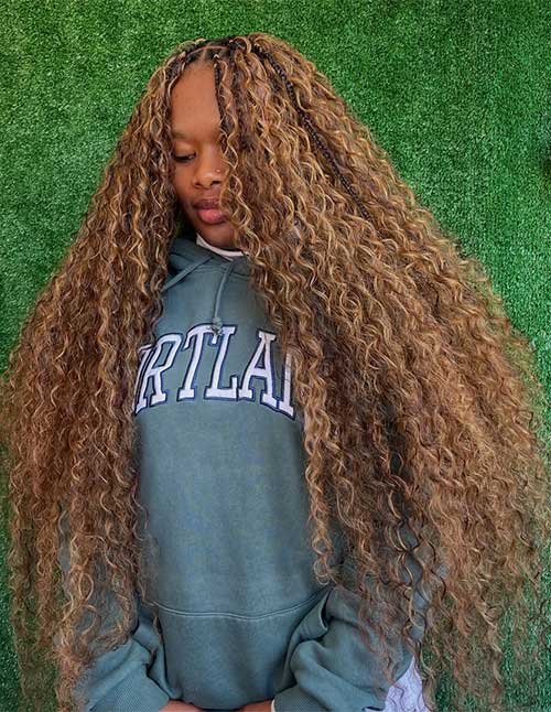 Side-swept goddess braids with long golden curls, draped over one shoulder.