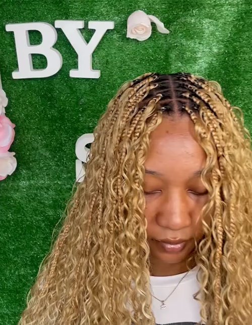 Goddess braids with loose curls featuring neat braided roots and long, flowing curly ends.