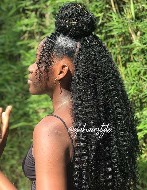 Side view of a woman with a half-up curly bun and long defined curls flowing down her back.