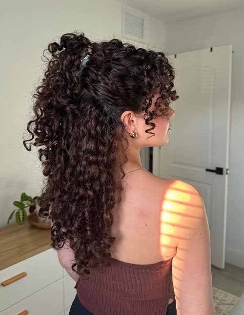 Half-up defined spring curls with high ponytail and face-framing ringlets
