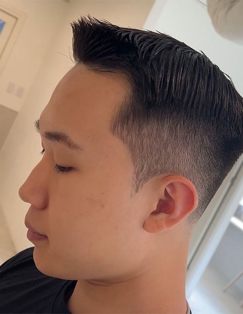 Ivy League Cut with a clean side part, tapered sides, and neatly brushed top with a slight lift in front.